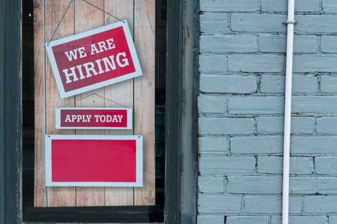 We Are Hiring red Sign hanging from a wooden door